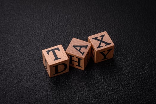The inscription tax on wooden cubes on a dark concrete background photo