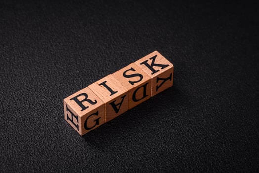 The inscription risk with wooden cubes on a dark concrete background photo