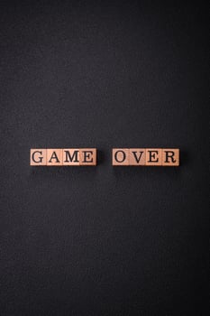 The inscription game over on wooden cubes on a dark concrete background photo