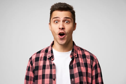Surprised male, keeps mouth open, being stunned, receives positive unexpected news, isolated over white background. Omg concept. Horizontal shot of shocked young male, expresses great surprised. photo