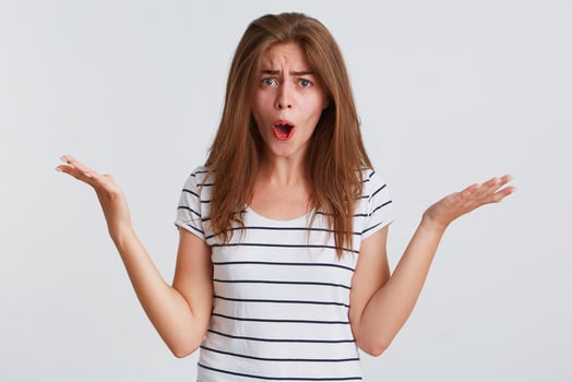 a woman is making a surprised face while holding her hands out photo
