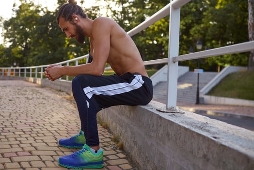 Young attractive bearded man has extreme sport in park, rest at the park after jogging, leads healthy active lifestyle. Fitness male model. photo
