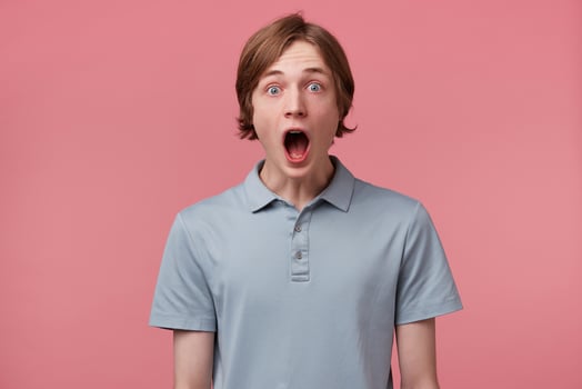 Surprised male, keeps mouth open, being stunned, receives positive unexpected news, isolated over pink background. Omg concept. Horizontal shot of shocked young male, expresses great surprisment. photo