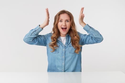 Photo of cute young blonde woman raises his hands up and scream in shock, isolated over white background. People and emotion concept.