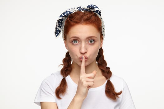 ginger young female shows silence gesture photo