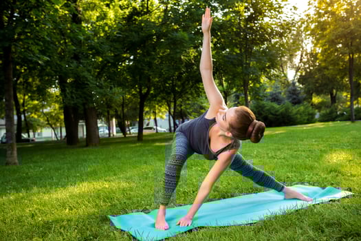 Young woman doing yoga exercises in the summer city park. photo