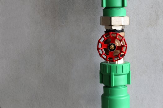 Water pressure gauge with valve in pipe on concrete wall background. photo
