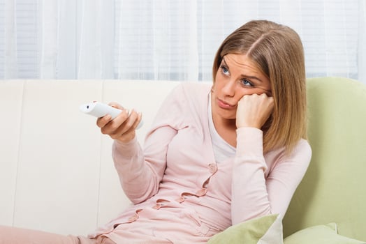 Sad woman changing channels photo
