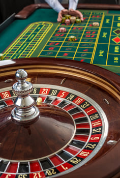 Roulette and piles of gambling chips on a green table. photo