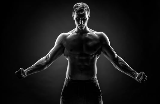 Strong man with his arms stretched out, looking at camera photo