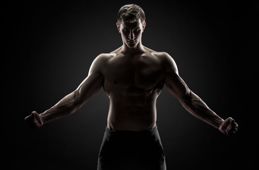 Strong man with his arms stretched out, looking at camera photo
