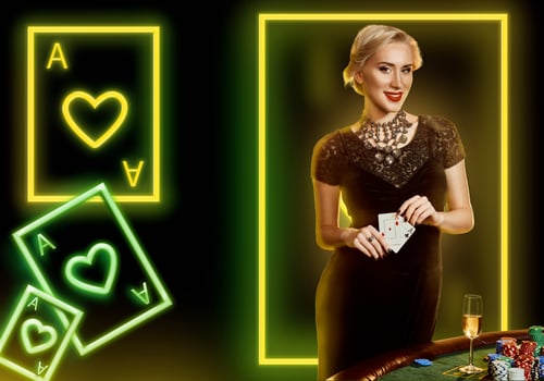 Woman in black dress showing aces, smiling, posing at table with chips, champagne. Black background with neon playing cards and frame. Poker, casino photo