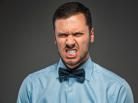 Portrait angry upset young man in blue shirt, butterfly tie photo