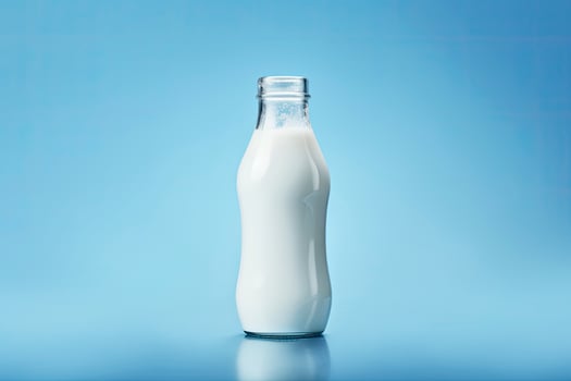 AI generated A glass bottle with full milk on blue background. photo
