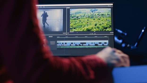 Professional video editor editing color grading and lighting in creative office, analyzing film montage, close up shot. Post production videographer manipulates raw footage, handheld camera shot photo