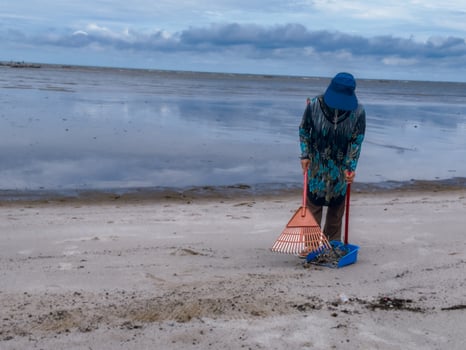 someone who is carrying out rubbish cleaning activities around the beach, green earth, coastal cleanup day photo