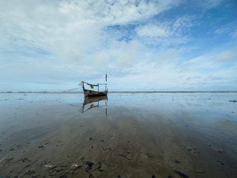 fishing boats stranded on the beach, preparing to leave by waiting for the tide photo