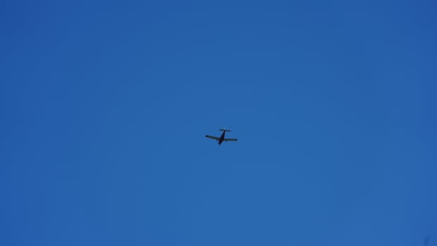 An airplane flying through the clear blue sky in the sunny day photo