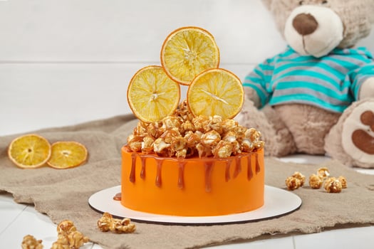 Orange cake with caramelized popcorn and candied citrus slices photo