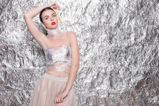 Young beautiful girl on a silver background. photo