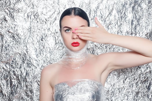 Young beautiful girl in a black dress on a silver background. photo