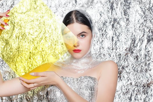 Young beautiful girl in a black dress on a silver background. photo