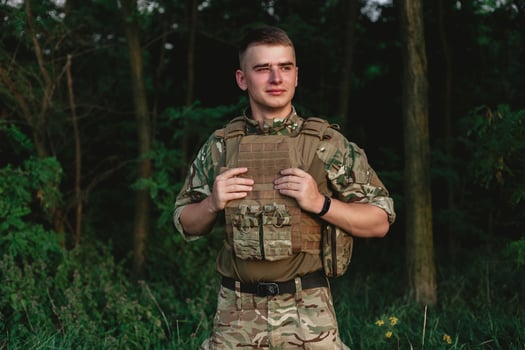 Soldier man standing against a field photo
