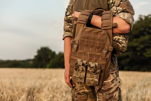 Soldier man standing against a field photo