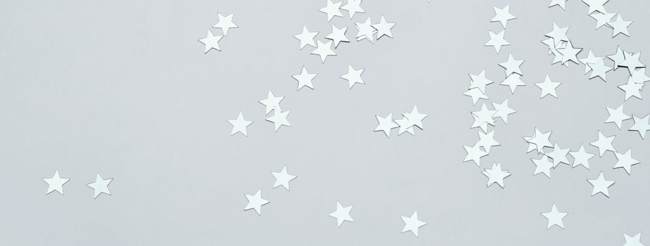 Silver stars confetti on gray banner. Christmas or winter festive background photo