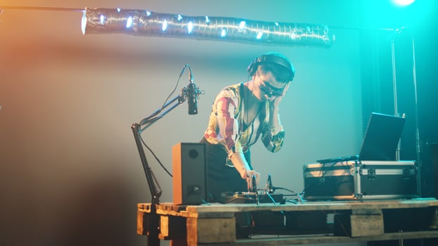 Woman artist mixing sounds at club party with dj turntables, using audio devices to play music and create modern remix at stereo. Having fun with disco equipment, nightclub. Handheld shot. photo