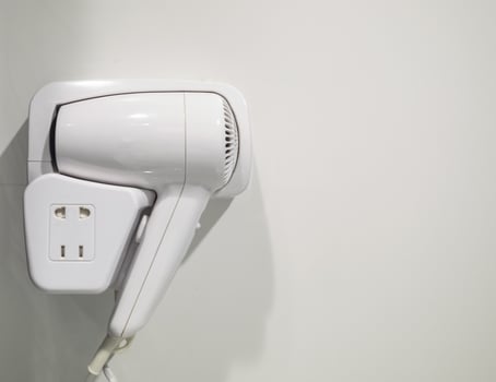 Hair dryer hanging on wall photo