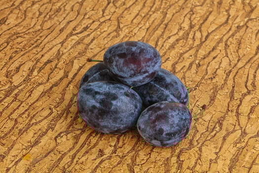 Ripe plum heap over background photo