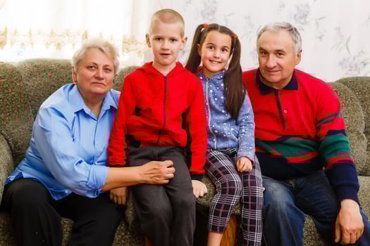 Grandparents and their young grandchildren relaxing at home photo