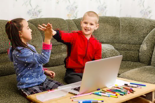 Two beautiful cute happy smiling children, a boy and a girl, use laptop for distance learning or entertainment. photo