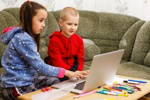 Two beautiful cute happy smiling children, a boy and a girl, use laptop for distance learning or entertainment. photo