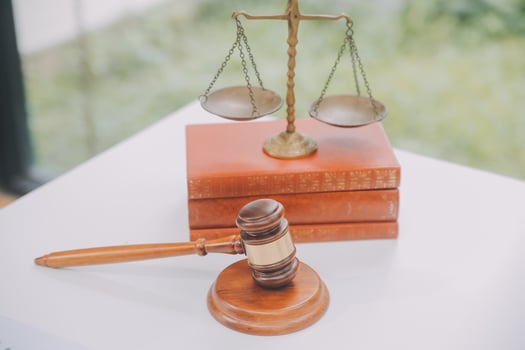 Business and lawyers discussing contract papers with brass scale on desk in office. Law, legal services, advice, justice and law concept picture with film grain effect photo