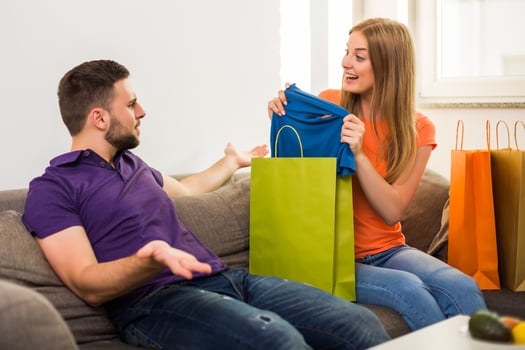 Couple having conflict because wife spent too much money on shopping while they sitting at sofa in their home. photo