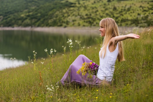 Woman with her arms outstretched enjoys spending her time in beautiful nature. photo