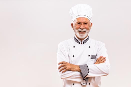 Portrait of senior chef  on gray background. photo