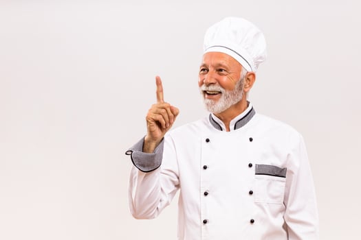 Portrait of happy senior chef having idea. photo