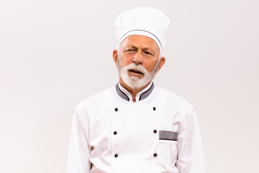 Image of exhausted senior chef on gray background. photo