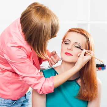 Make up artist applying  make up on a beautiful woman photo
