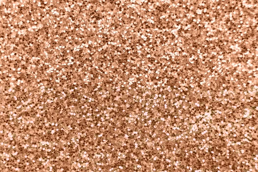 glittering background of Peach Fuzz sequins closeup. Sparkle festive texture photo