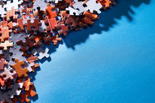 Mixed Peaces of a Colorful Jigsaw Puzzle Lie on the Blue Background With Copy Space Strategy and Solving Problem Concept photo