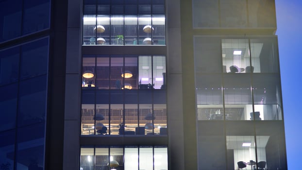Fragment of the glass facade of a modern corporate building at night. Modern glass office in city. photo