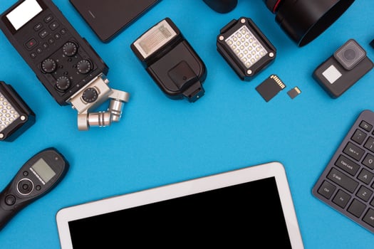 Top View of Photographer's, Videographer's or Video Blogger's Workplace. Digital Gadgets Lying on Blue Table Flat Lay photo