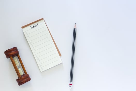 Time management concept, to do list with notepad and black pencil on white desk. photo