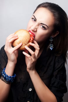 girl eating a big hamburger, studio photo