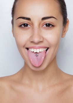 Beautiful woman sticking out her tongue and showing young piercing photo
