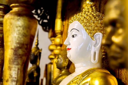 Closeup and side view ancient golden Buddha statue of Burmese art in sanctuary at Wat Phra That Hariphunchai Lumphun Thialand. photo